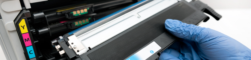 Een hand haalt een toner uit een laserprinter